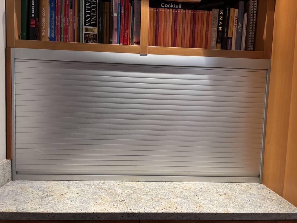 Serrandina sottopensile chiusa, finitura in alluminio, integrata in una nicchia da cucina